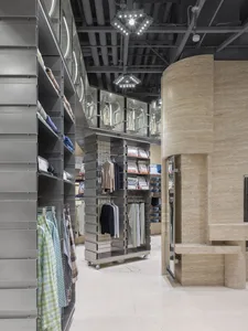 A modern retail interior featuring metallic clothing racks and shelves.