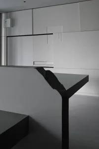 A minimalist bedroom with a concrete floor and walls, featuring a sleek design and modern style.
