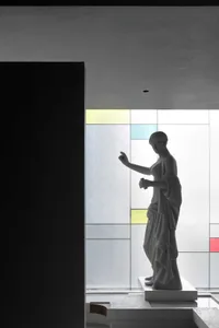 簡約辦公室室內空間，設有玻璃窗與雕像