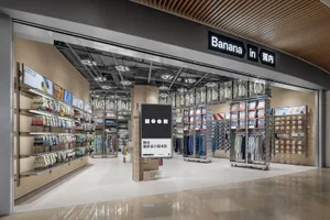 一間現代服飾店，內有展示架、層架與招牌。