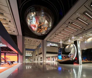 An industrial-style shopping center interior with metallic architectural elements and a futuristic design.