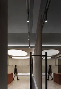 A minimalist shopping center with metallic finishes and circular light fixtures.