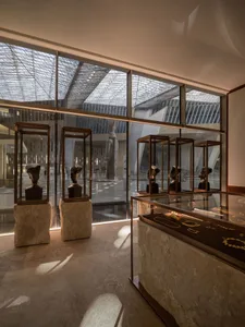 Glass display cases in an art museum interior, showcasing modern sculptures and jewelry.