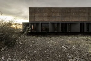 Modern building exterior made of concrete in a desert setting.