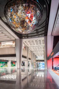 A modern glass retail space with a large spherical light fixture hanging from the ceiling.
