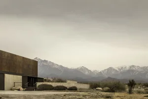 Modern house with concrete exterior in a desert setting.