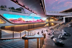 A modern interior space featuring metallic sculptures and a large digital display with a colorful digital art installation.