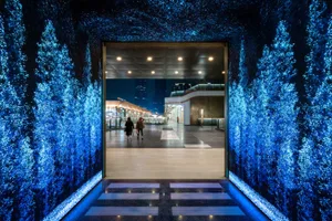 A modern lobby illuminated with glass walls and blue LED lighting.