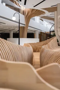 Modern public space designed with wooden elements, featuring contemporary seating and architectural elements.