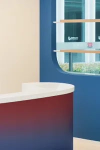 A sleek, minimalist reception desk made of a clear laminated board, featuring a white countertop with a smooth, curved design