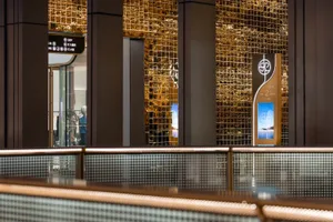 A shopping center interior with glass and metal bookshelves and illuminated flooring.