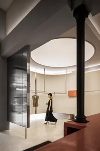 A minimalist clothing store features concrete, metal, and wood materials.