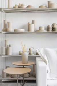 A modern home displaying an extensive ceramic collection, including vases, bowls, cups, and plates.