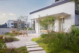 Modern outdoor space featuring concrete flooring, gravel patio, and glass walls.