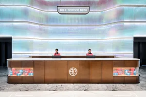 Modern, minimalist service desk featuring wooden panels and glass with LED lighting.