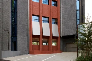 Modern building exterior featuring brick walls, concrete elements, and aluminum accents.