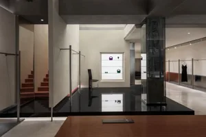 Modern minimalist retail space featuring polished concrete surfaces, glass showcases, and minimalist decor.