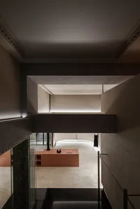 Minimalist shopping center interior with concrete floors and walls, featuring a modern retail storefront with glass display c