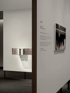 A minimalist installation featuring mixed media elements, including a photo and text.