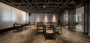 A minimalist cafe with wooden furniture and high ceiling