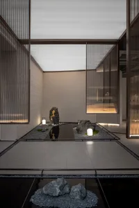A minimalist lobby featuring a concrete floor and illuminated elements.