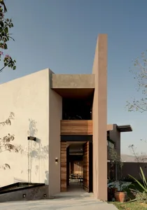 Minimalist residential entrance featuring concrete and wood materials.