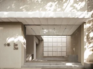 A minimalist retail storefront with concrete walls and a glass façade.