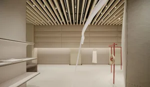 Minimalist retail store interior with timber slat ceiling, concrete floor, and white clothing rack.