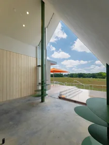 Modern interior design featuring concrete flooring, with a view of greenery outside.