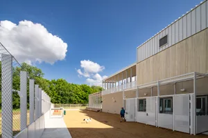 Concrete industrial-style dog kennel building with a person and dog
