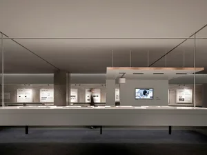 Minimalist exhibition space featuring concrete, glass, and metal materials.