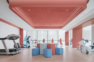 A well-equipped fitness center with a red finish plasterboard ceiling
