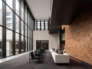 Modern minimalist lobby with a concrete floor, large windows, and minimalist furniture.
