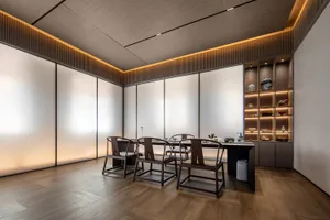 Modern minimalist tea room with wooden furniture and white walls.