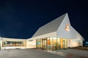 Modern, single-story, office building with a metallic exterior and large glass windows.