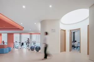 A modern office space featuring glass walls, white walls, and wooden accents.