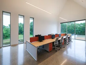 A modern office space featuring workstations with minimalistic design and natural lighting.