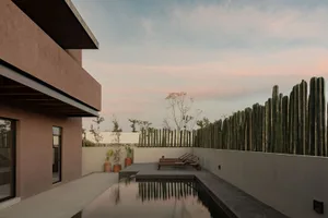 Modern residential pool area with concrete walls and floor, featuring a calm water surface.