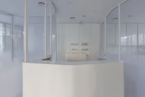 A modern reception counter with glass walls and a minimalist design.