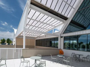 Modern exterior of a restaurant featuring glass walls and a metal frame