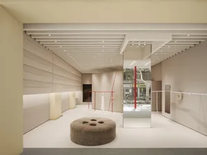Modern retail store with textured beige walls and red accents