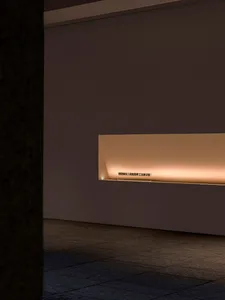 A minimalist interior design featuring concrete surfaces and warm lighting.