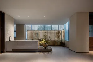 Modern lobby interior with marble, glass, and concrete elements.