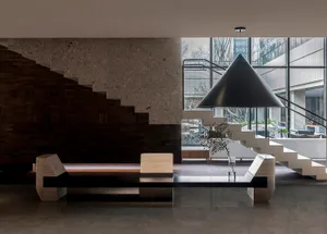 A modern minimalist lobby featuring concrete materials and geometric shapes.