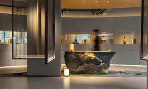 A sleek, modern museum display featuring granite and illuminated vases.