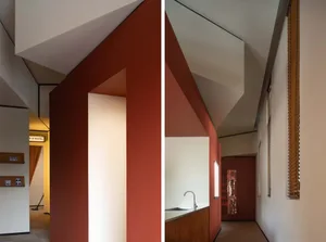 An image showcasing the modern design of a residential hallway with red brick walls and a contrasting white ceiling.