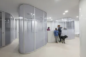 Modern office interior with curved glass walls and white floors and ceiling.