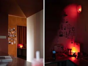 A dimly lit photography studio with a metal frame and red lighting hanging on the wall.
