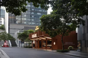 Modern building exterior with metal cladding, designed for a restaurant, featuring large glass windows, a canopy, and a small