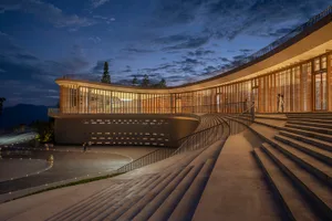 A modern building with curved concrete exterior and glass windows.